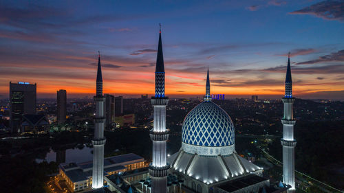 Modern buildings against sky during sunset