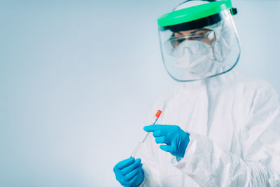 Corona virus test - medical worker in protective suite with swab sample for pcr dna testing