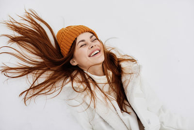 Portrait of beautiful young woman against white background