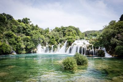 Scenic view of waterfall against sky