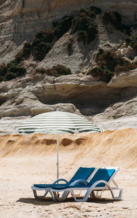 Deck chairs under parasol at beach