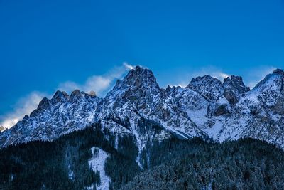 Scenic view of snowcapped mountains against blue sky