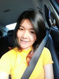 Portrait of smiling young woman in car