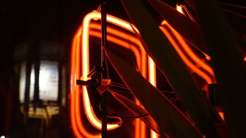 Low angle view of illuminated lighting equipment at night