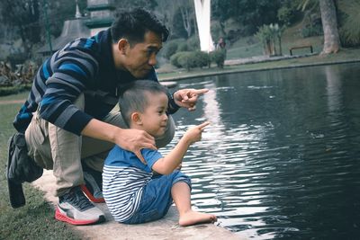 Full length of father and son by lake