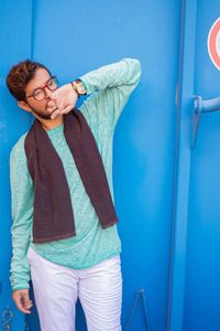 Portrait of young man standing against wall