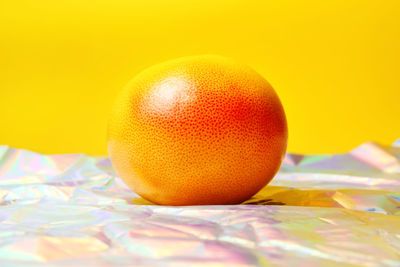 Whole of orange grapefruit on yellow background and modern foreground. healthy food concept. 