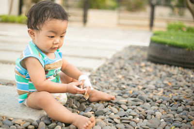 Cute boy sitting on stone