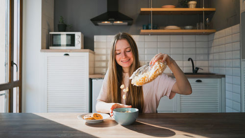 Young woman eating food at home