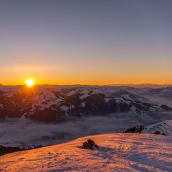 Scenic view of snowcapped mountains against sky during sunset