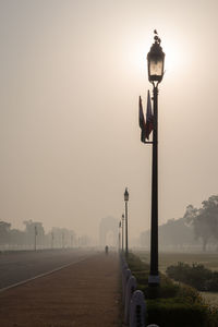 Sun behind street lamp in rajpath, road to india gate, delhi. india