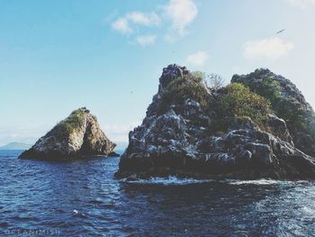 Rock formation in sea against sky