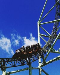 Low angle view of amusement park ride against blue sky
