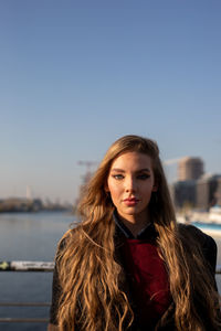 Portrait of beautiful woman standing against clear sky