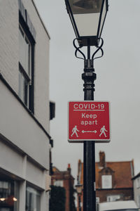 Low angle view of road sign on street against buildings