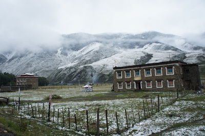 Built structure on snowcapped mountain against sky