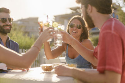 Young people toasting with mojitos cocktails on happy hour after coronavirus lockdown