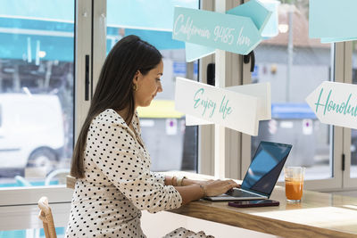 Woman using phone while standing on table