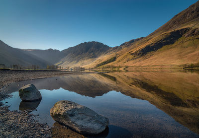 Scenic view of lake and mountains against clear sky