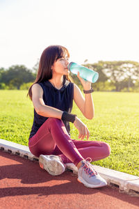 Full length of woman sitting on field