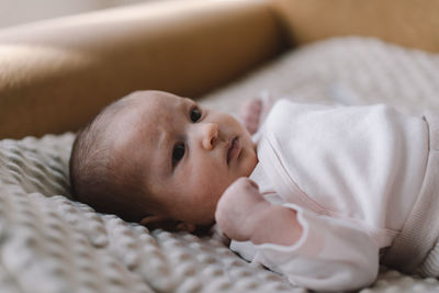 Portrait of a 1 month old baby. cute newborn baby lying on a developing rug.