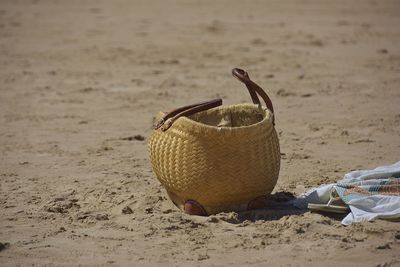 Close-up of wicker basket on sand