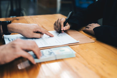 Midsection of businessman working on table