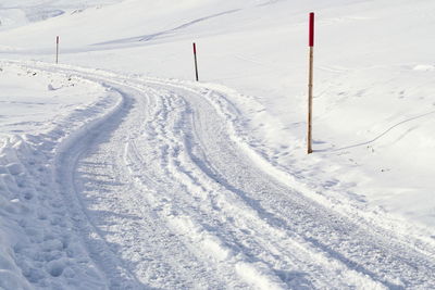 Tire tracks on snow covered landscape