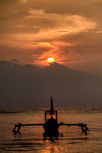 Silhouette people on boat against sky during sunset