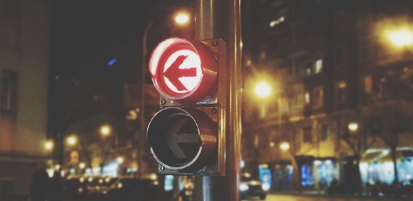 Close-up of illuminated sign on city at night