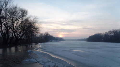Scenic view of frozen river against sky during winter