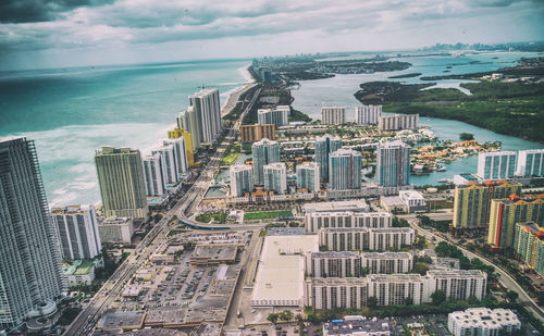 High angle view of buildings by sea against sky