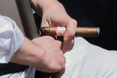 Close-up of man holding cigar