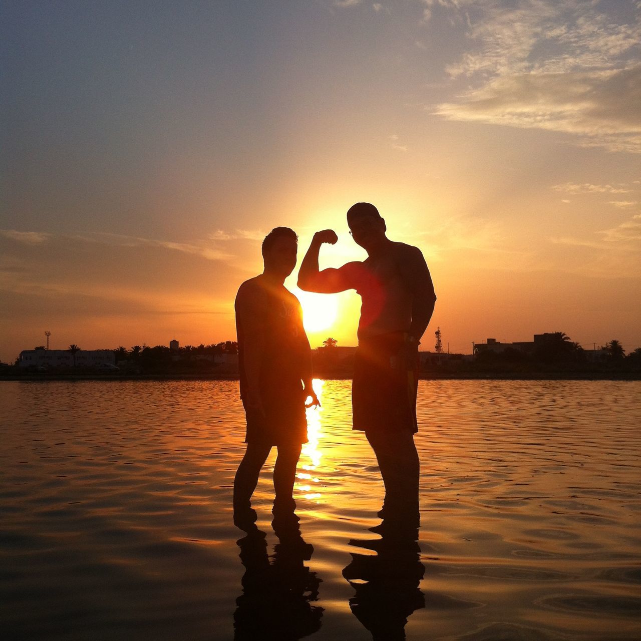 silhouette, lifestyles, leisure activity, sunset, men, sea, water, beach, sky, person, full length, enjoyment, sun, shore, standing, playing, sunlight