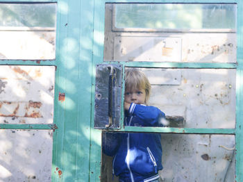 Boy looking through closed window