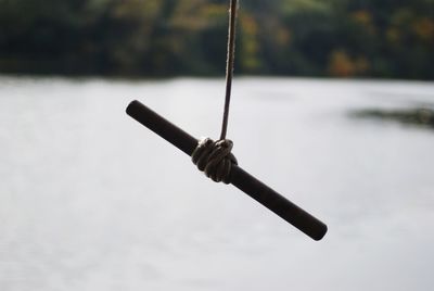Close-up of fishing rod on rope over lake