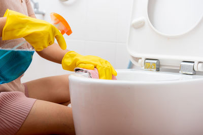 Midsection of woman washing hands in bathroom