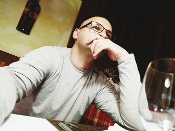 Man looking away while sitting in restaurant