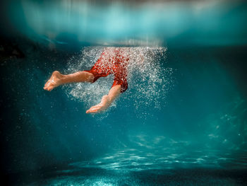 Underwater picture of a boy swimming in a pool