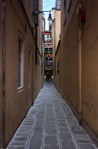 View in narrow lane in city of venice with entrance of a house at the end.