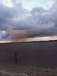 Man standing on beach against sky during sunset