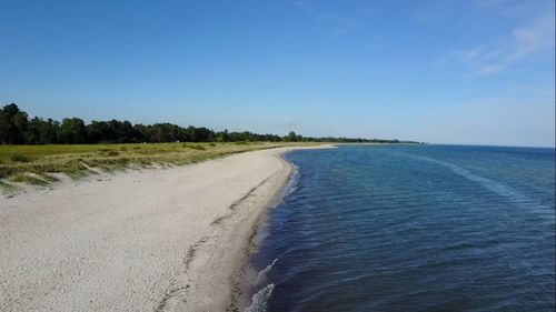 Scenic view of beach against clear blue sky