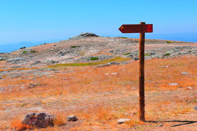 Low angle view of cross on land against clear sky