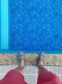 Low section of woman standing by swimming pool