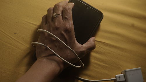 Close-up of hand holding mobile phone on table