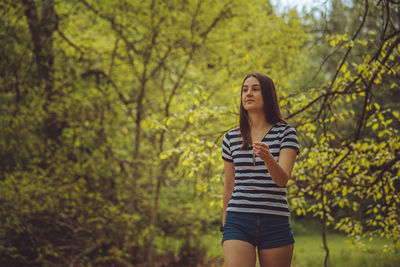 Young woman standing in forest