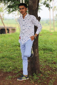 Full length portrait of young man standing on field
