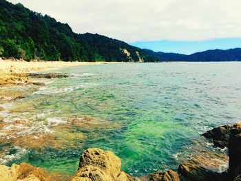 Scenic view of sea and mountains against sky