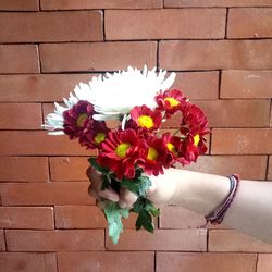 Close-up of hand holding flowers