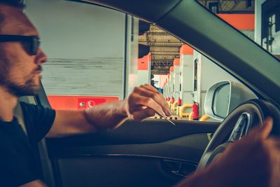 Midsection of man holding camera in bus